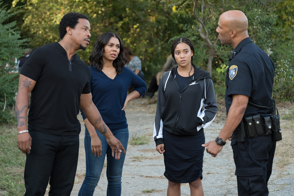 A policeman talking with the Carter Family from The Hate U Give