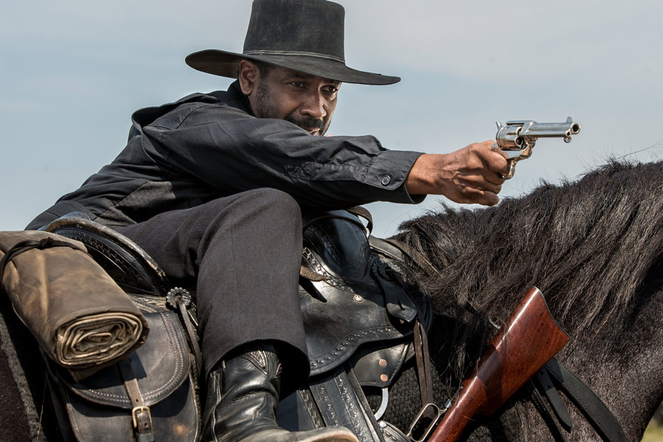 A still of Denzel Washington on a horse pointing his gun, from the film The Magnificent Seven